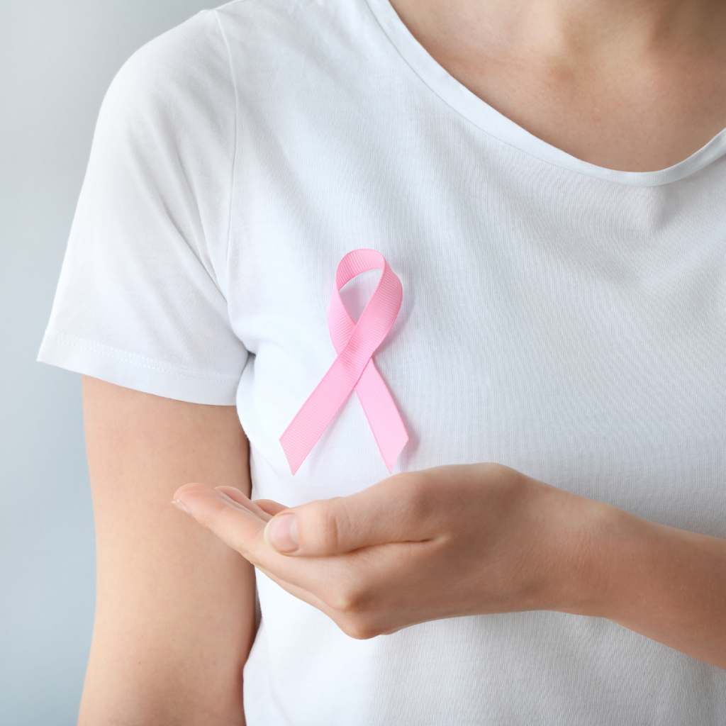 IH - Breast Cancer and You 1. Woman wearing a pink breast cancer awareness ribbon on her shirt.