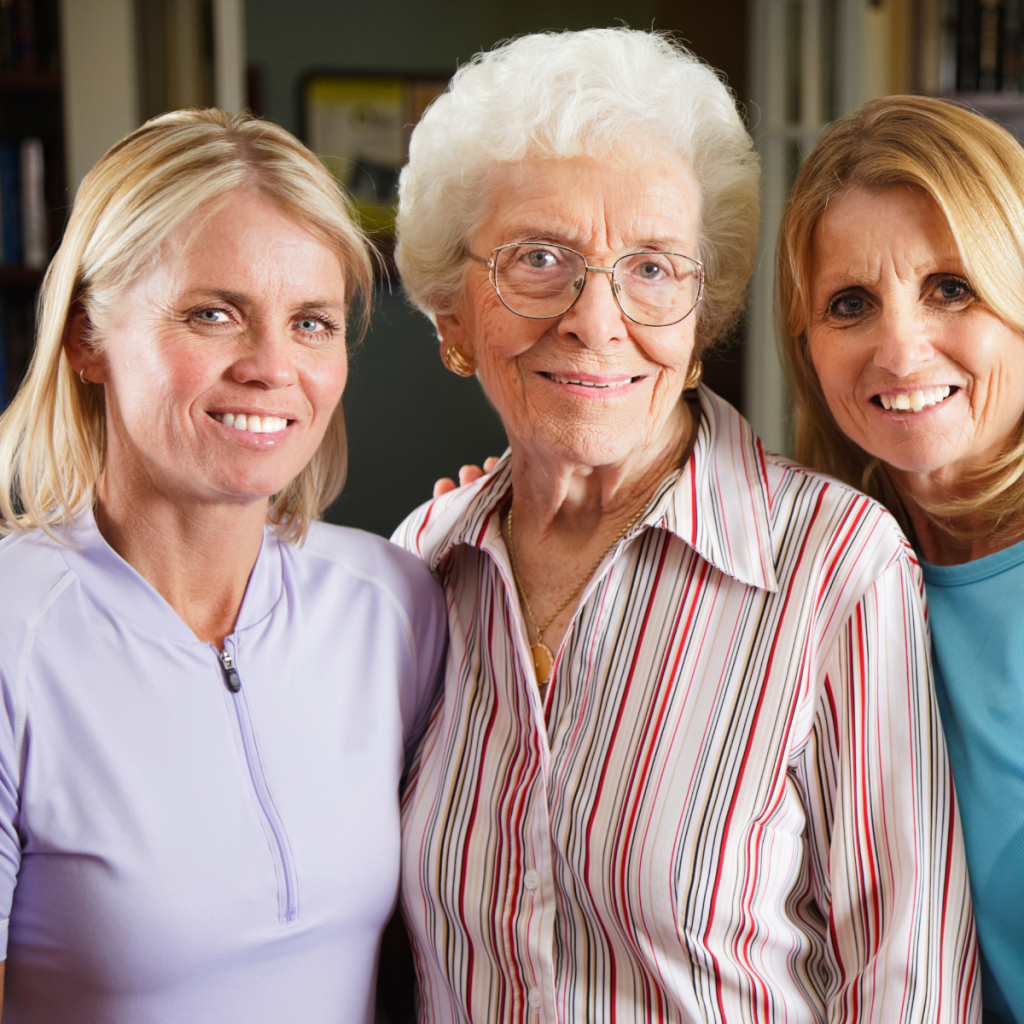 IH - Family History Breast Cancer Older woman standing with two adult women in a family portrait.